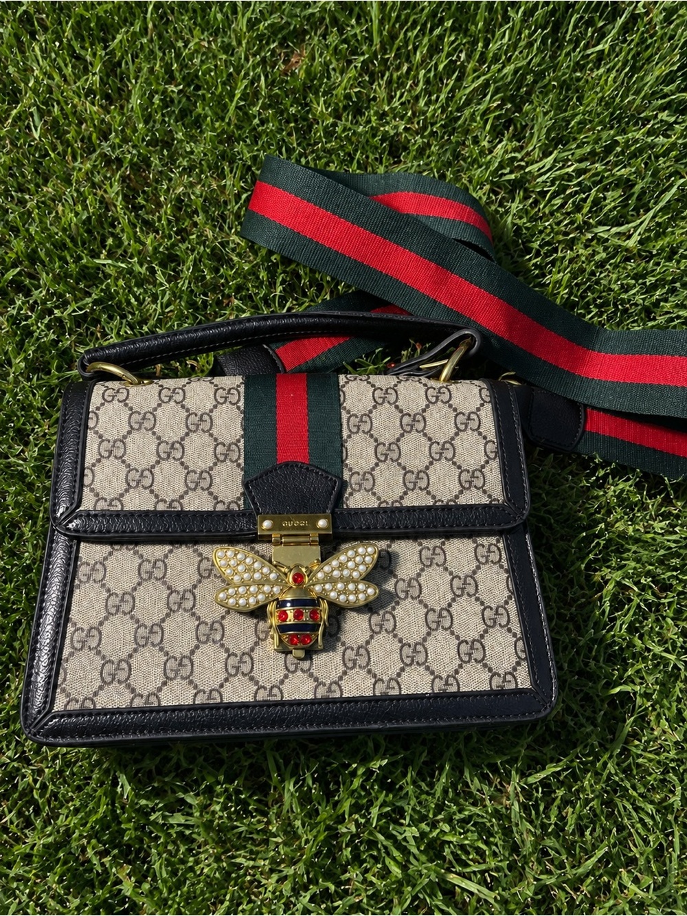 Brown and black handle bag with green and red strip